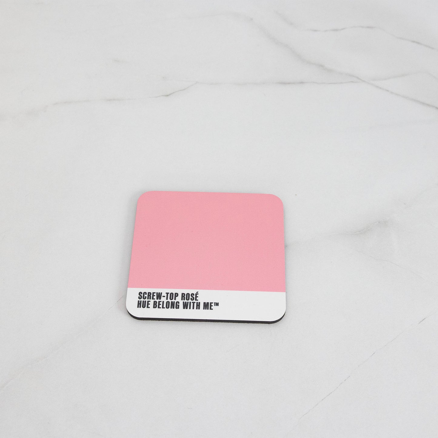 Warm nostalgic pink cork-back coaster, flat lay on marble counter — Screw Top Rosé by Hue Belong With Me