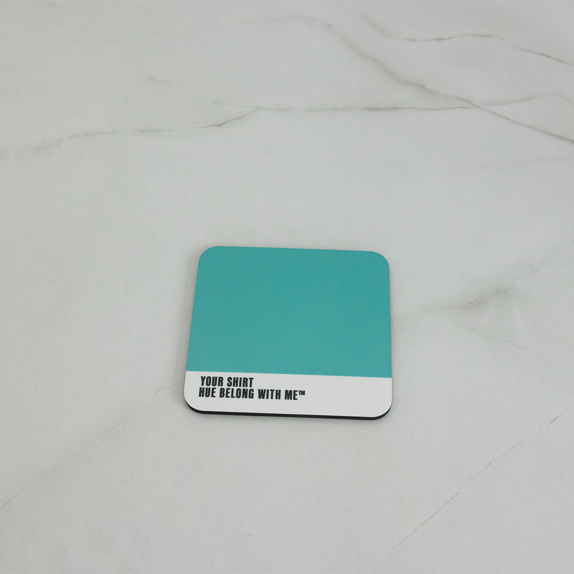 Crisp high-contrast teal cork-back coaster, flat lay on marble counter — Your Shirt by Hue Belong With Me